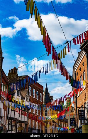 Colourful bunting suspended above a historic street in Cambridge city centre, Cambridgeshire, England, UK. Stock Photo
