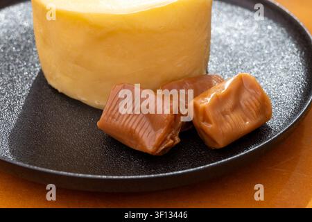Creamy golden French handmade on farm butter from Brittany and caramel candies with sea salt flavor. Premium artisanal dairy product of Brittany. Stock Photo
