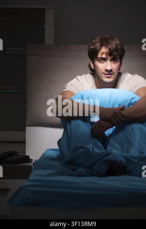 Young handsome man suffering from insomnia in bed Stock Photo