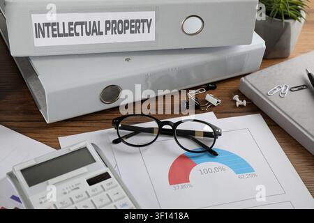 Intellectual property. Folders, documents and stationery on wooden table Stock Photo