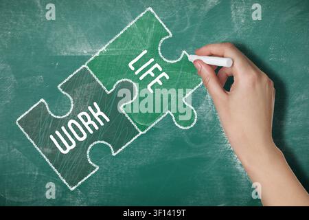 Life and work balance. Woman drawing puzzle pieces on green chalkboard, closeup Stock Photo