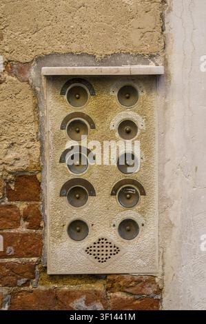 Vintage intercom with multiple buttons mounted on a stucco wall, part brick Stock Photo