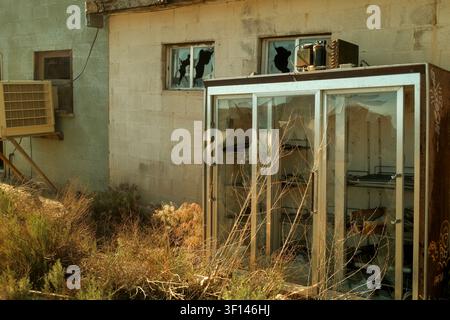 Damaged storefront and broken windows at an abandoned commercial building in Green River, Utah, USA. Stock Photo