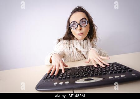 Funny nerd girl working on computer Stock Photo