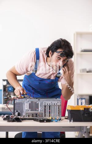 Young male contractor repairing computer Stock Photo