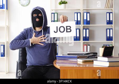 Male thief in balaclava in the office Stock Photo