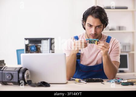 Young male contractor repairing computer Stock Photo