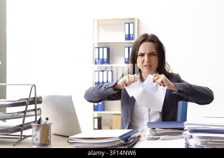 Young female employee unhappy with excessive work Stock Photo