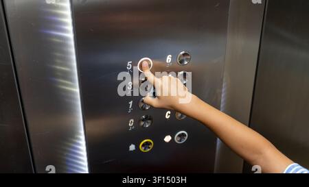 Child Pressing Elevator Button Inside Modern Lift Close Up Stock Photo