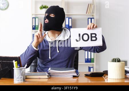 Male thief in balaclava in the office Stock Photo