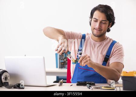 Young male contractor repairing computer Stock Photo