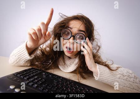 Funny nerd girl working on computer Stock Photo