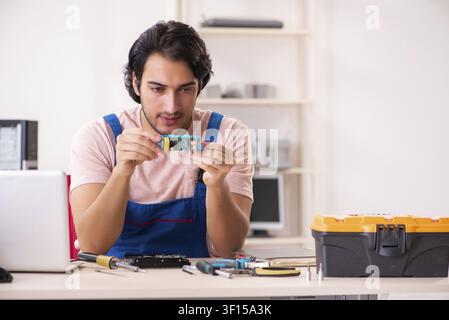 Young male contractor repairing computer Stock Photo