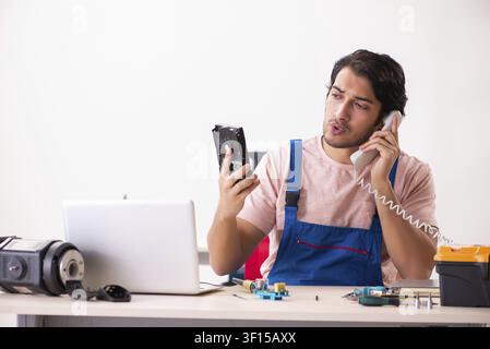 Young male contractor repairing computer Stock Photo