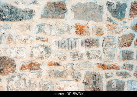 Weathered stone wall texture with natural limestone masonry background. Stock Photo