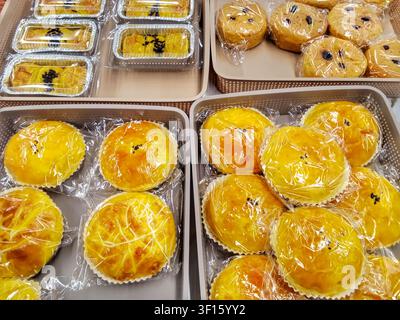 Assorted Traditional Indonesian Sweet Breads and Pastries Wrapped in Plastic on Display Trays Stock Photo