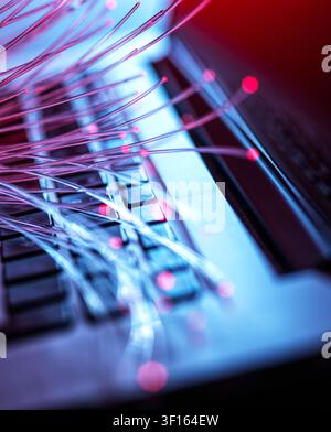 Fibre optics carrying data to a laptop. Stock Photo