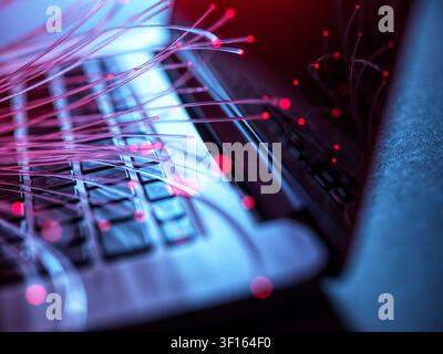 Fibre optics carrying data to a laptop. Stock Photo