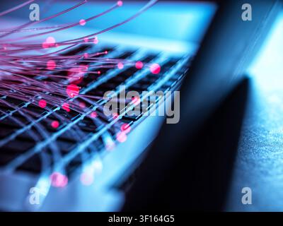 Fibre optics carrying data to a laptop. Stock Photo