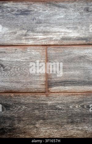 High-resolution close-up of dark grey ceramic floor tiles imitating aged wood plank design. High quality porcelain tiles with natural grain pattern, s Stock Photo