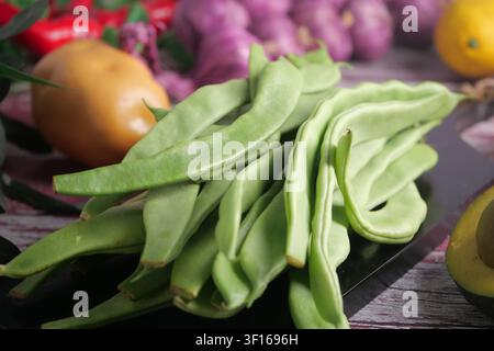 Fresh green beans and vibrant vegetables on a rustic table Stock Photo