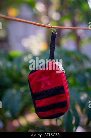 Red Mini Hanging Pouch on Natural Green Background Stock Photo