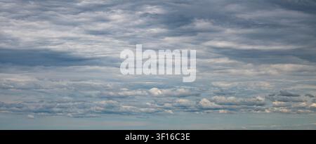 Panoramic summer cloudscape with layered altocumulus and cumulus clouds in a pale blue sky, Minnesota. Stock Photo