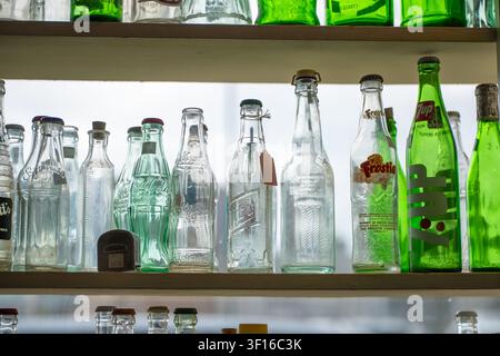 DULUTH, MN - 24 JUN 2026: Vintage glass soda bottles including Coca-Cola, 7-Up and Frostie brands displayed on shelves in a Duluth, Minnesota antique Stock Photo