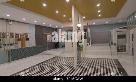 Bright Minimalist Modern Hotel Lobby Black White Checkered Tile Floor Soft Warm Yellow Recessed Ceiling Light Neutral Interior Stock Photo