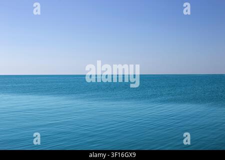 Calm Turquoise Blue Ocean Water Surface Under Clear blue Sky Stock Photo