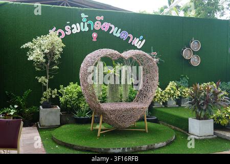 Resort Photo Spot Heart Shaped Rattan Sofa Green Grass Wall Thai Script Sign Tropical Plant Stock Photo
