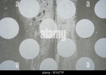 The image features a textured gray background with a pattern of large, irregularly placed white circles. The circles appear to be painted or stenciled Stock Photo