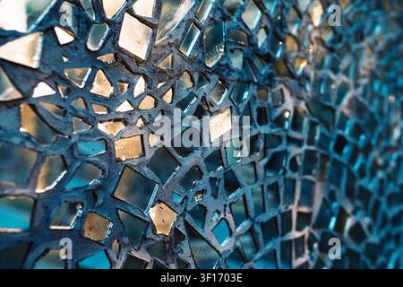 Detailed macro view of a decorative wall mosaic made from shattered mirror glass shards embedded in grey concrete Stock Photo