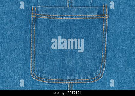 Close up detail of classic blue denim fabric. Symmetrical view of jean pocket with double orange stitching. Timeless apparel texture and background fo Stock Photo