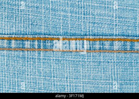 Closeup of blue denim fabric with white grid pattern and two parallel orange stitches. Textured weave, even lighting, minimalist style. Ideal for fash Stock Photo