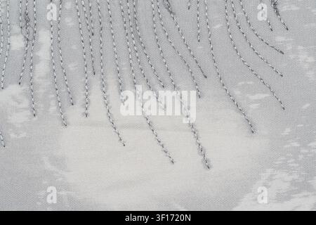 Textured gray fabric with diagonal stitching pattern creating visual rhythm. Soft lighting highlights thread texture fabric weave. Minimalist style wi Stock Photo