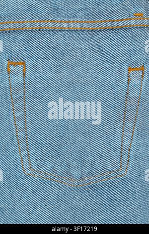 Detailed texture of blue denim fabric with orange stitching outlining back pocket. Focus on weave pattern seam detail. Minimalist composition with eve Stock Photo