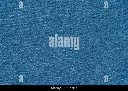 Detailed macro shot of blue denim fabric. Classic indigo textile shows intricate weave and thread pattern. Perfect as neutral, textured background for Stock Photo