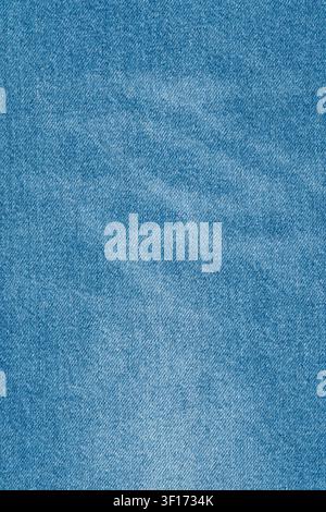 Detailed macro shot of light blue denim texture. Classic jean fabric background with visible twill weave and faded areas. Versatile, casual, and timel Stock Photo