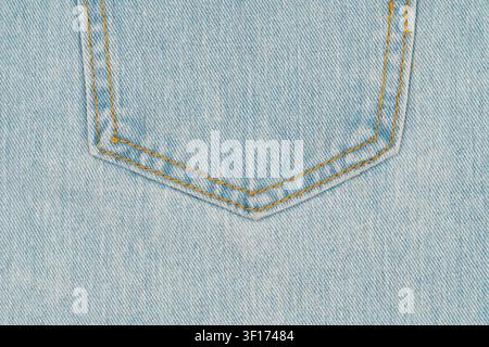 Close up macro shot of light blue denim fabric. Classic jeans back pocket with double yellow stitching creates symmetrical detail. Perfect for fashion Stock Photo