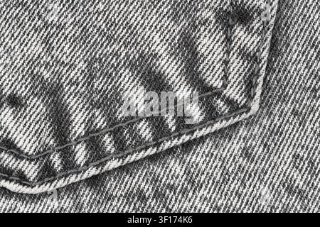 Gray denim fabric closeup showing pocket detail and stitching. Textured cotton textile background. Fashion material surface for clothing design and ap Stock Photo