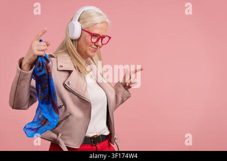 Mature woman dancing enjoying music in headphones Stock Photo