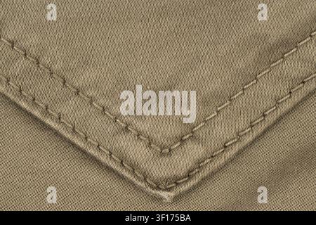 Textured olive green fabric with precise diagonal stitching forming V shape. Soft lighting highlights weave pattern thread detail Stock Photo