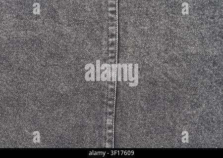 Macro shot of grey denim fabric. Detailed texture of woven cotton material with vertical stitching down center. Neutral, monochrome background for fas Stock Photo