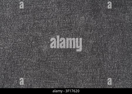 Macro shot of dark gray or black denim fabric. Detailed textile background shows classic diagonal twill weave pattern. Versatile texture for fashion, Stock Photo