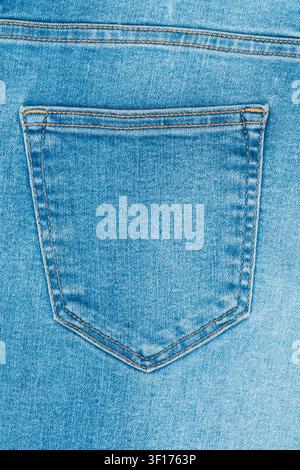 Close up of light blue denim fabric. Classic back pocket design with double yellow stitching. Natural, even lighting highlights material texture. Perf Stock Photo