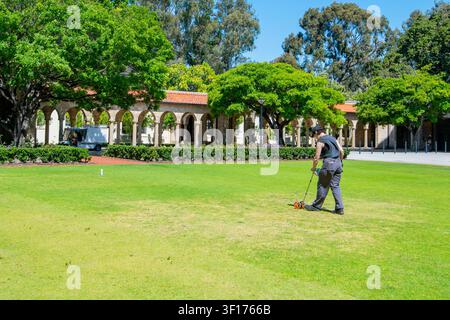 Worker Using a Surveyor's Wheel on the Grass Stock Photo