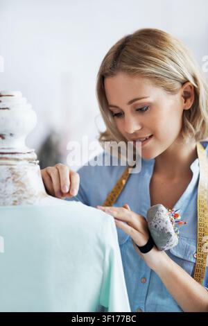 Pin, fabric and woman with mannequin in startup, adjusting and fashion designer with measuring tape. Check, seam and happy person with sewing project Stock Photo