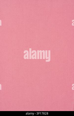 Closeup macro shot of pink denim fabric. Detailed textile background shows uniform color and distinct diagonal twill weave. Perfect for design, fashio Stock Photo