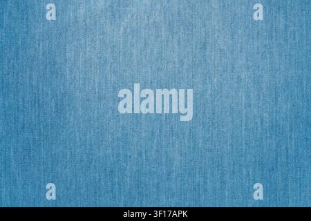 Close up of blue denim fabric with visible weave pattern and subtle color variations. Soft even lighting highlights texture. Ideal for fashion, design Stock Photo